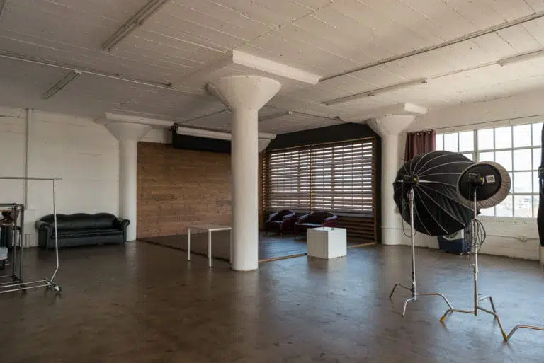Stage with a wooden corner, large blinds and a marquee star available for rental in Los Angeles