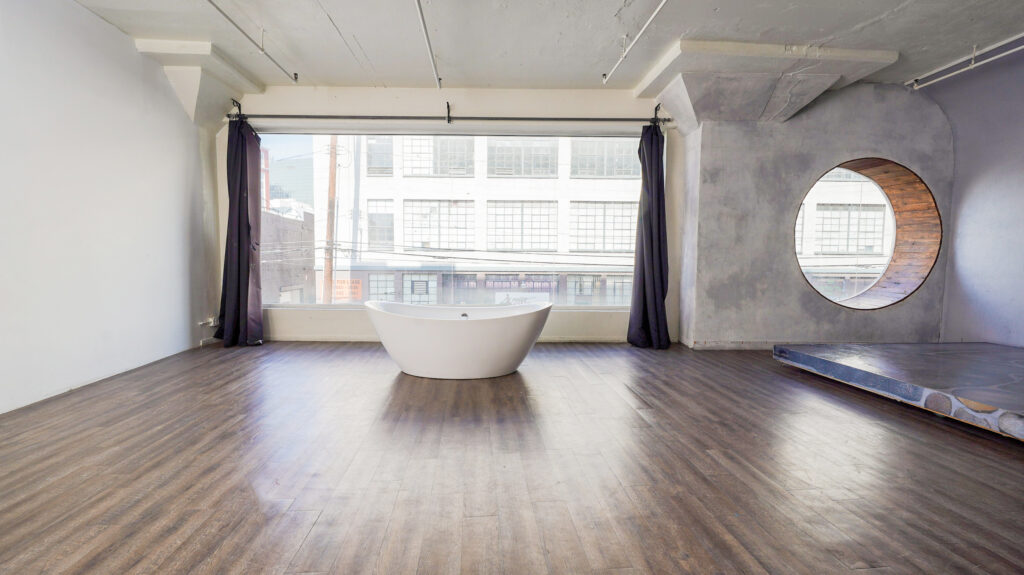 A photo studio near me Pro I with the circle window, bathtub and art wall in los Angeles.