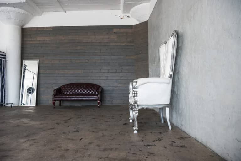 Photo and Video studio with concrete textured wall, red sofa and white extra large chair available for rental In Los Angeles Photo and Video studio with concrete textured wall, red sofa and white extra large chair available for rental In Los Angeles