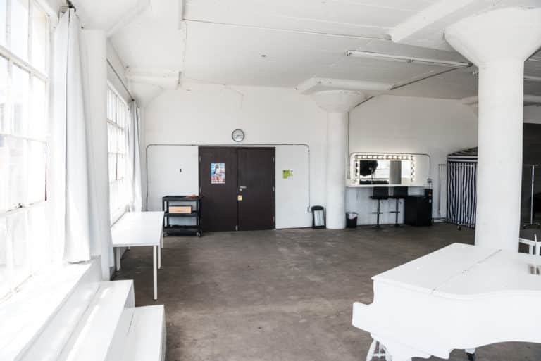Photo and Video studio with concrete textured wall, red sofa and white extra large chair available for rental In Los Angeles Photo and Video studio with concrete textured wall, red sofa and white extra large chair available for rental In Los Angeles