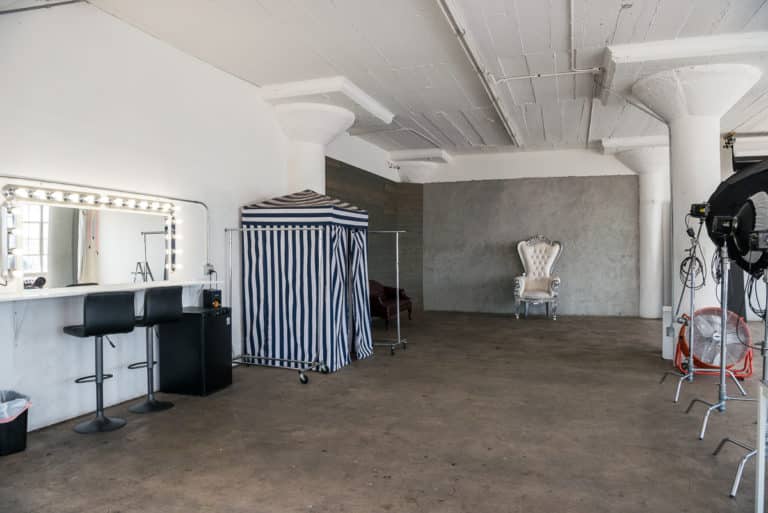 Photo and Video studio with concrete textured wall, red sofa and white extra large chair available for rental In Los Angeles Photo and Video studio with concrete textured wall, red sofa and white extra large chair available for rental In Los Angeles